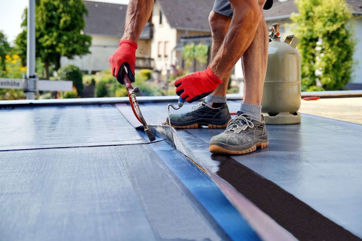 Flat roof being repaired by our Wimbledon roofing team